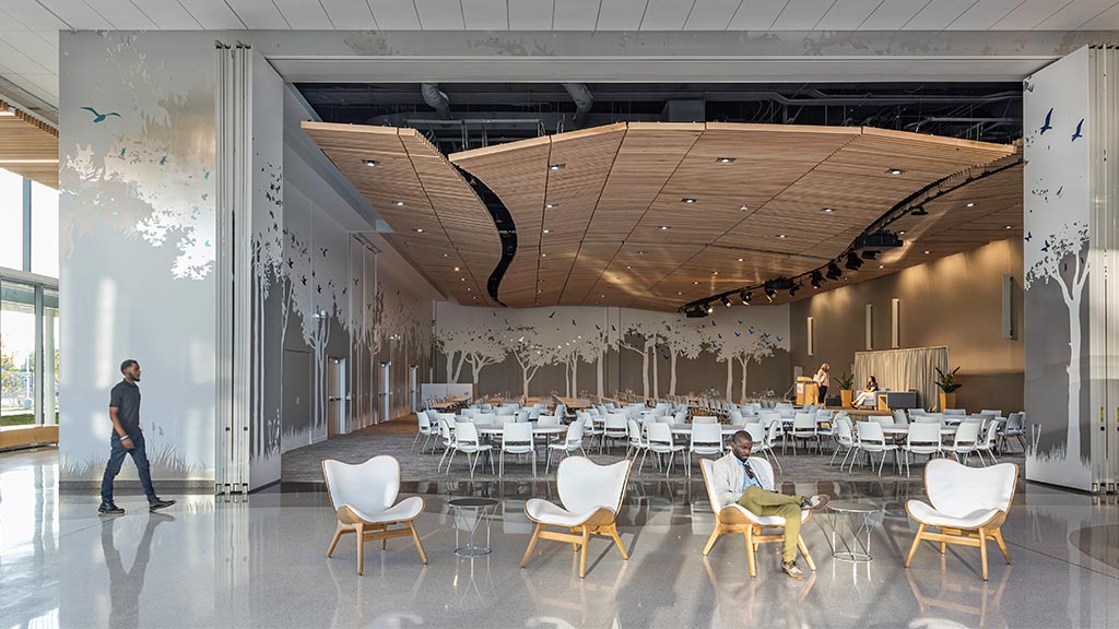 A person walking by a table with chairs and tables.