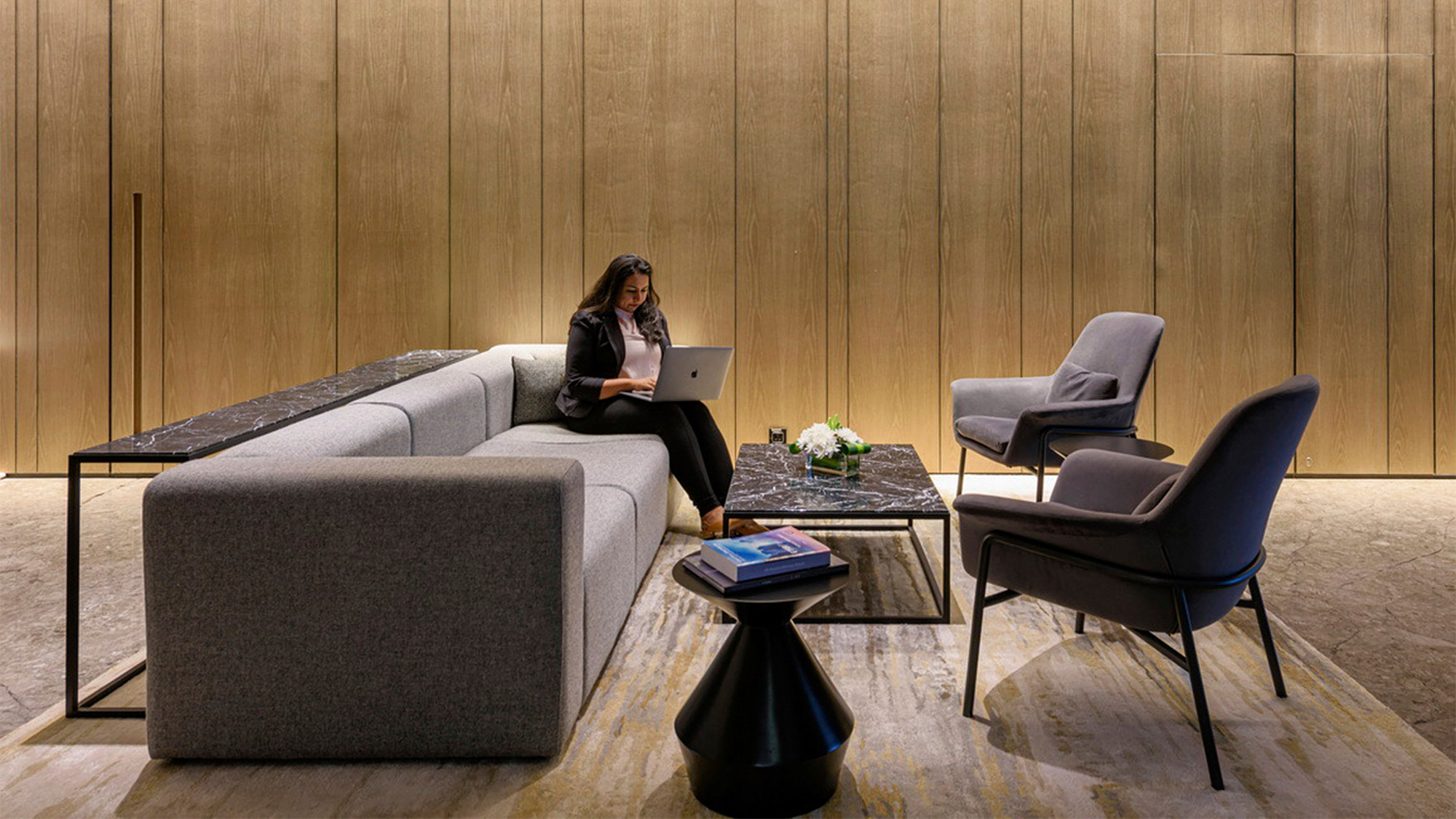 A person sitting on a couch with a laptop.